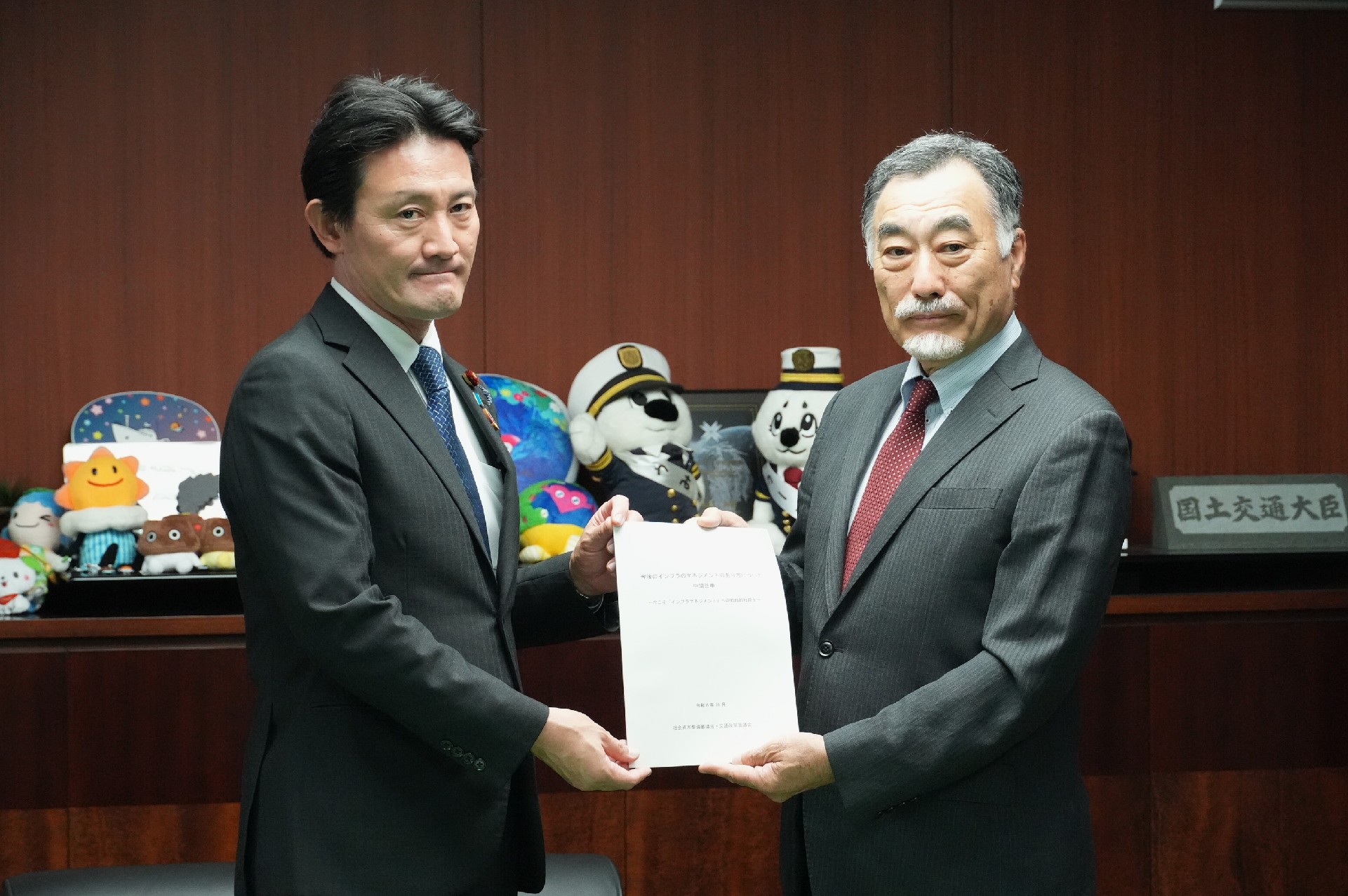 中間答申を手交する家田委員長(右)と井林国交相
